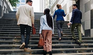 four people walking up steps talking