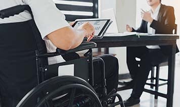 person in wheelchair working at laptop 