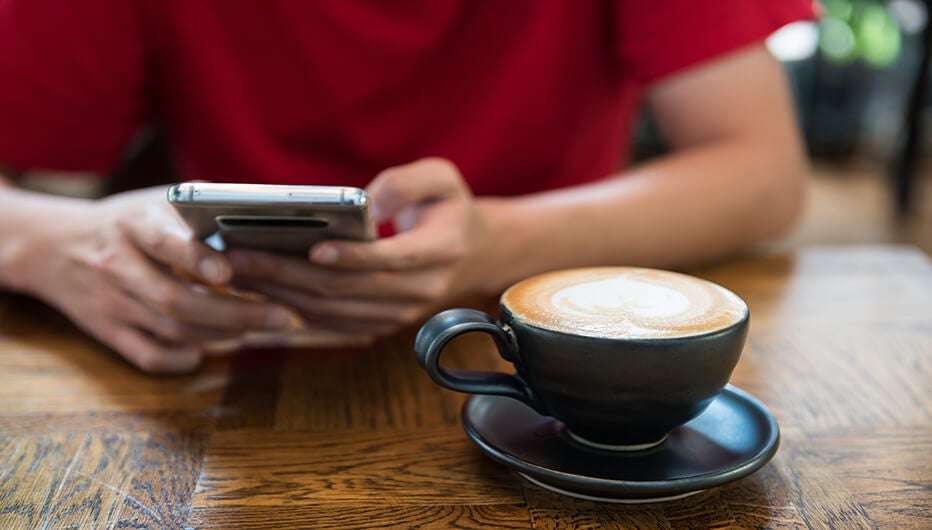 Man with phone having coffee