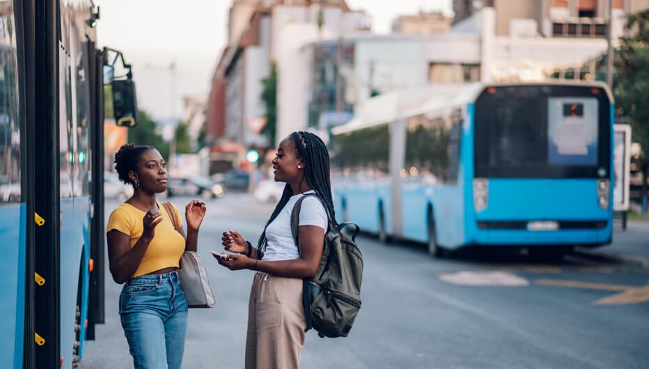 women talking outside bus