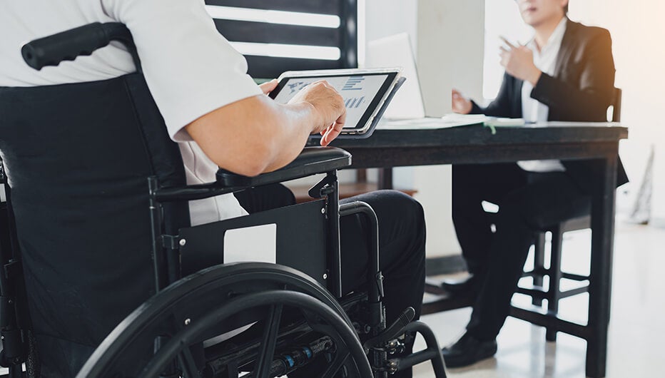 person in wheelchair with tablet