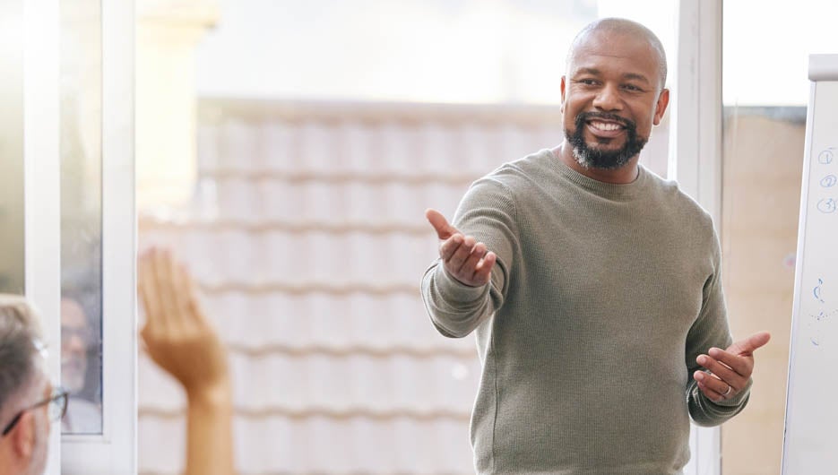 Group, speaker and man with a presentation, feedback and question with growth, mentor and coaching. Male person, leader and staff in a workshop, meeting or company development with planning or review.