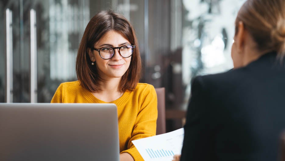 Group of happy business people have meeting at workplace in office. Two positive woman working together using modern laptop for working concept