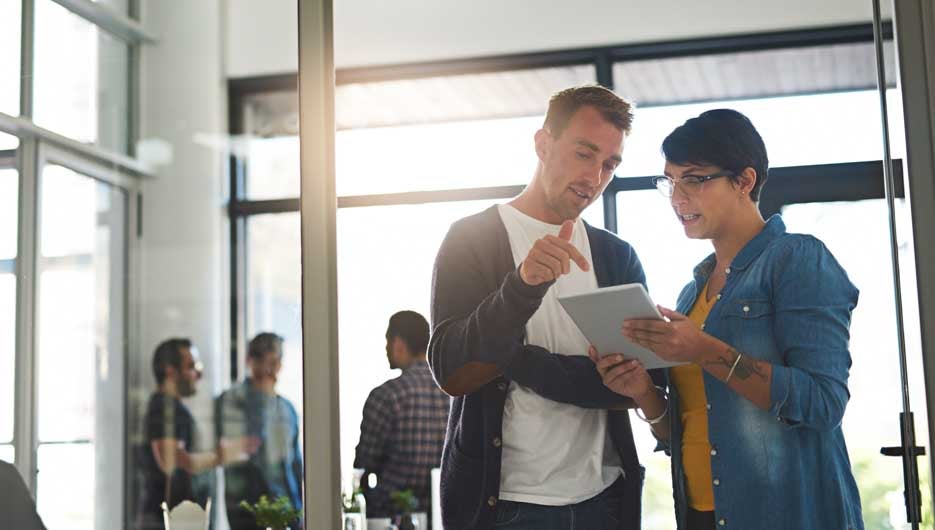 Shot of a two colleagues having a conversation before meeting in the boardroom.