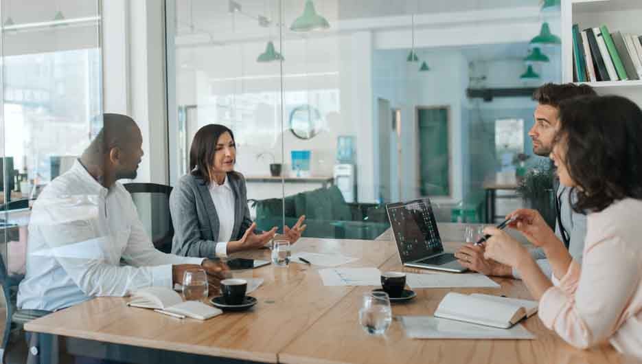 Diverse group of businesspeople talking together inside of an of
